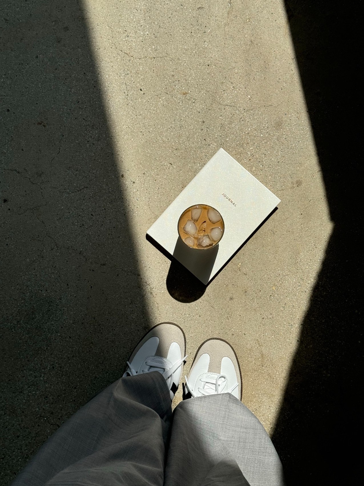 Iced coffee on a journal in the sunlight