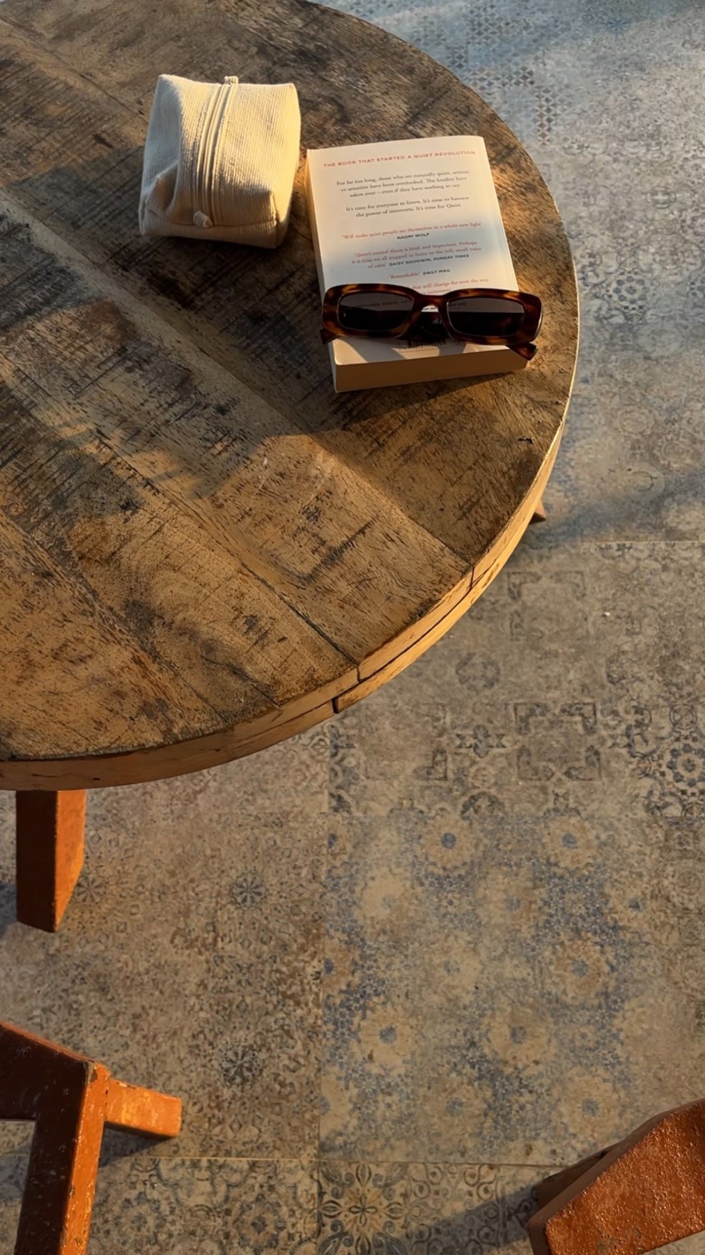 Open books on a substantial wooden table in natural light